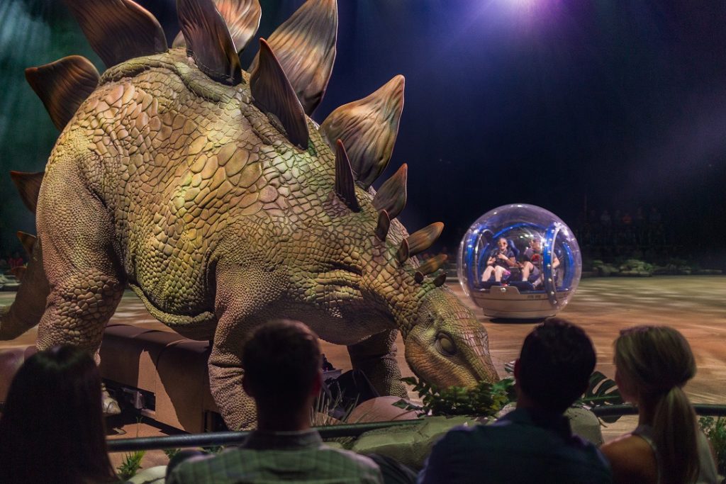 Scene from Jurassic World Live Tour featuring a Stegosaurus and Gyrosphere. 