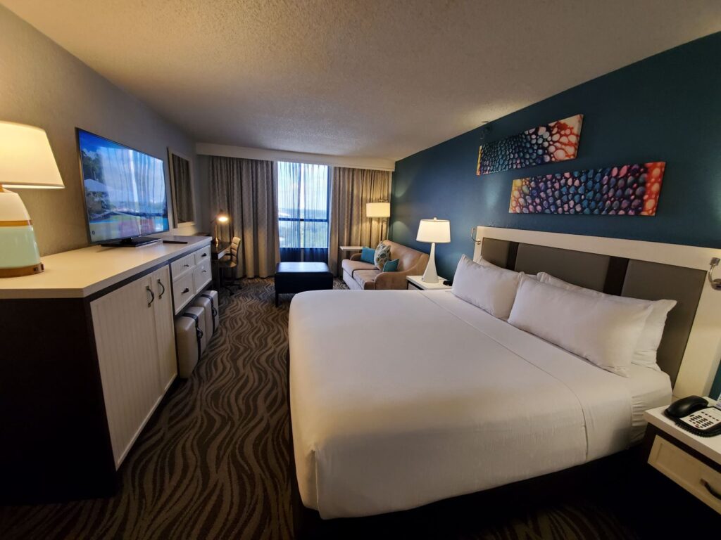 Room with king bed and couch at Wyndham Lake Buena Vista in Disney Springs Resort area.